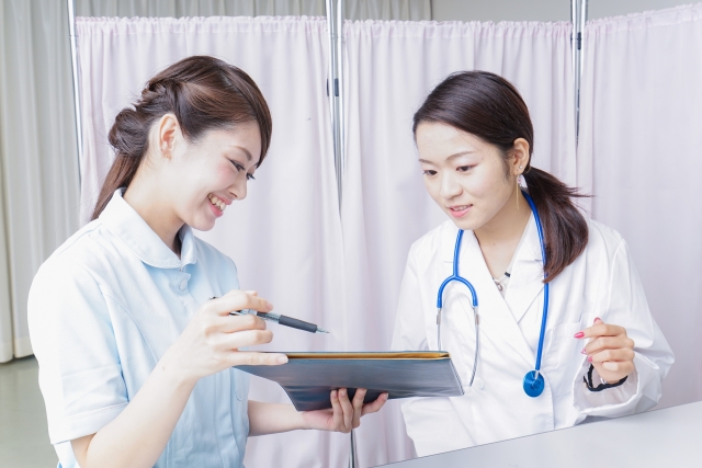 医療スタッフがタブレットを見ながら相談する様子